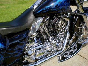 Custom aluminum air cleaner and floor boards shown on  shown on a black Harley Davidson motorcycle accented with blue flame design