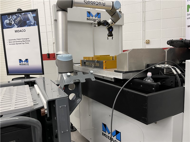Midaco Hydraulic Docking System attached to yellow vices on an aluminum rectangle pallet on the surface of an Automatic Pallet Changer. Upper right shows a detail image of Automatic Pallet Changer with Cobot robot arm moving parts on the pallet.